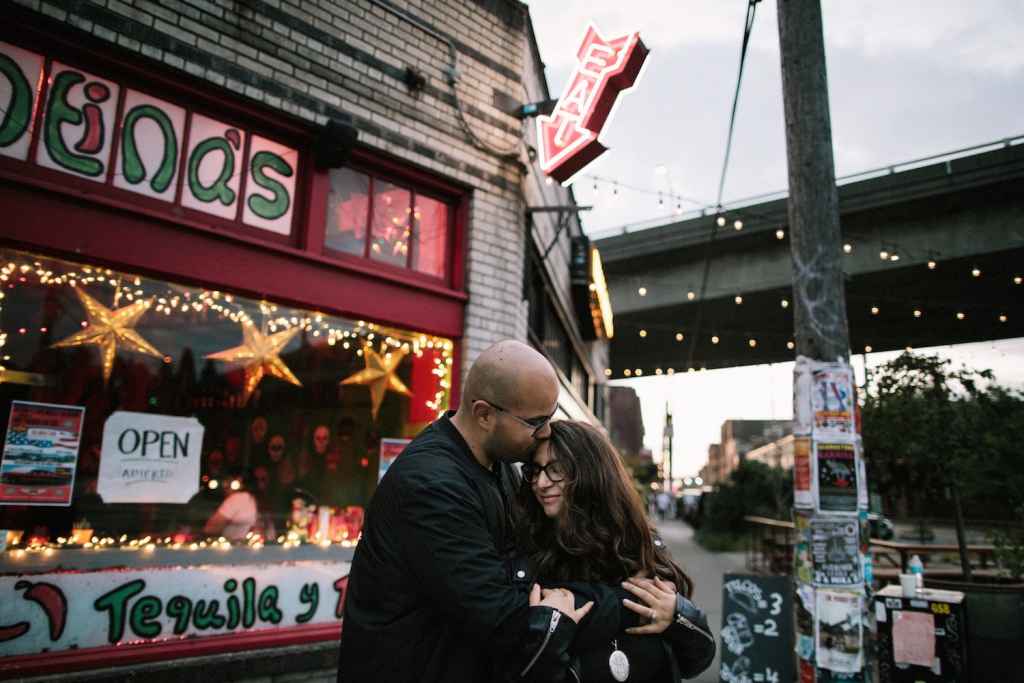 couple embracing at georgetown in seattle in front of vibrant storefront