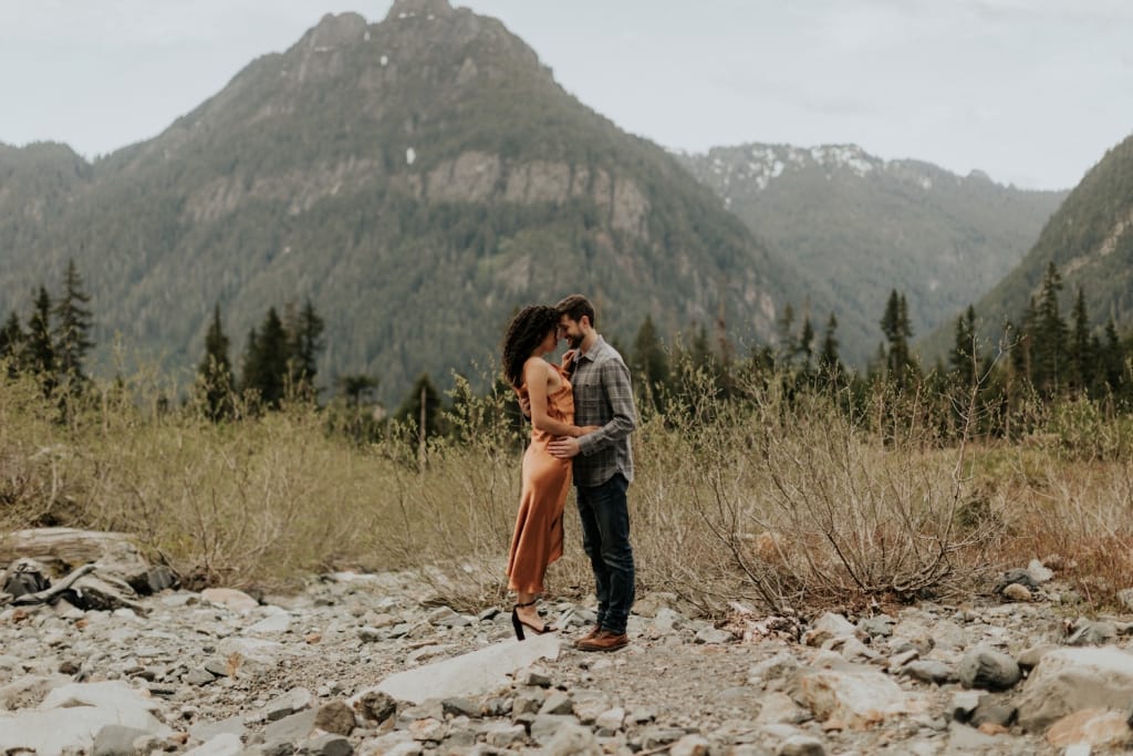 woman and man hold each other on rugged terrain of cascades national park in seattle area