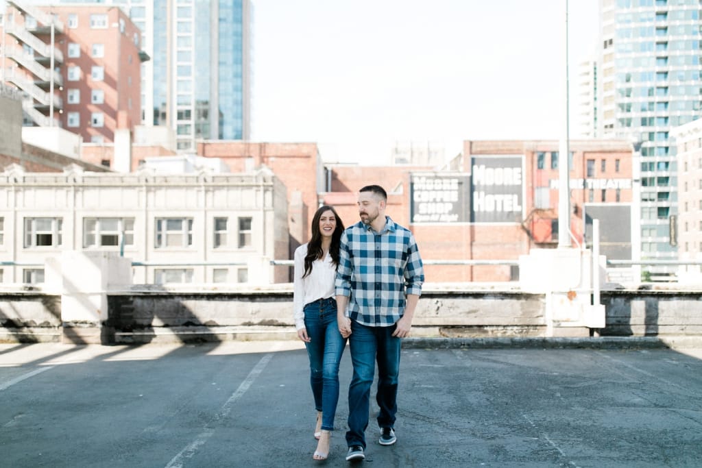 couple posing for engagement photography on downtown seattle rooftop