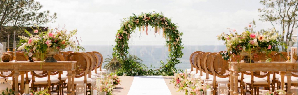 floral displays and chairs set up for a wedding on the deck of l’auberge del mar in san diego