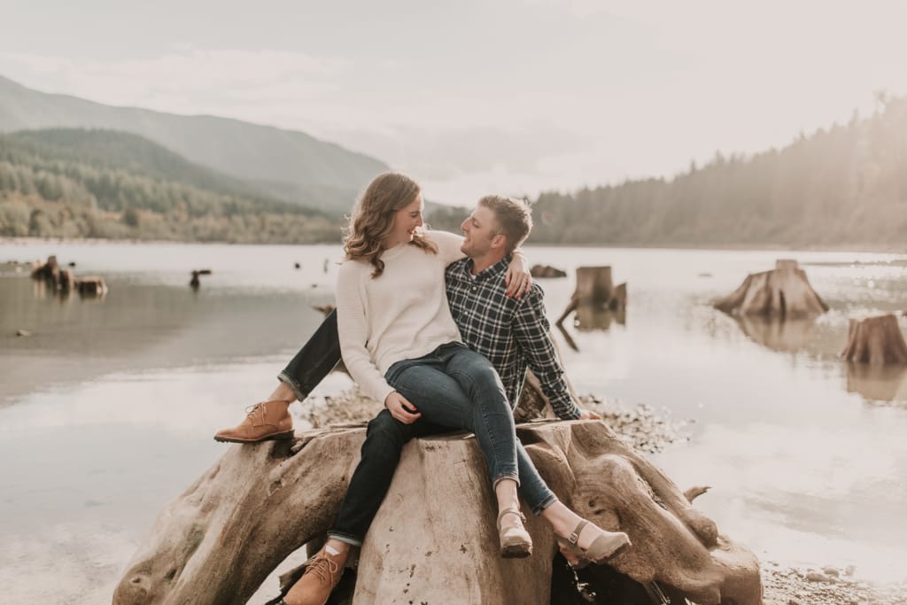 couple embracing at rattlesnack lake in seattle with mountains in the background