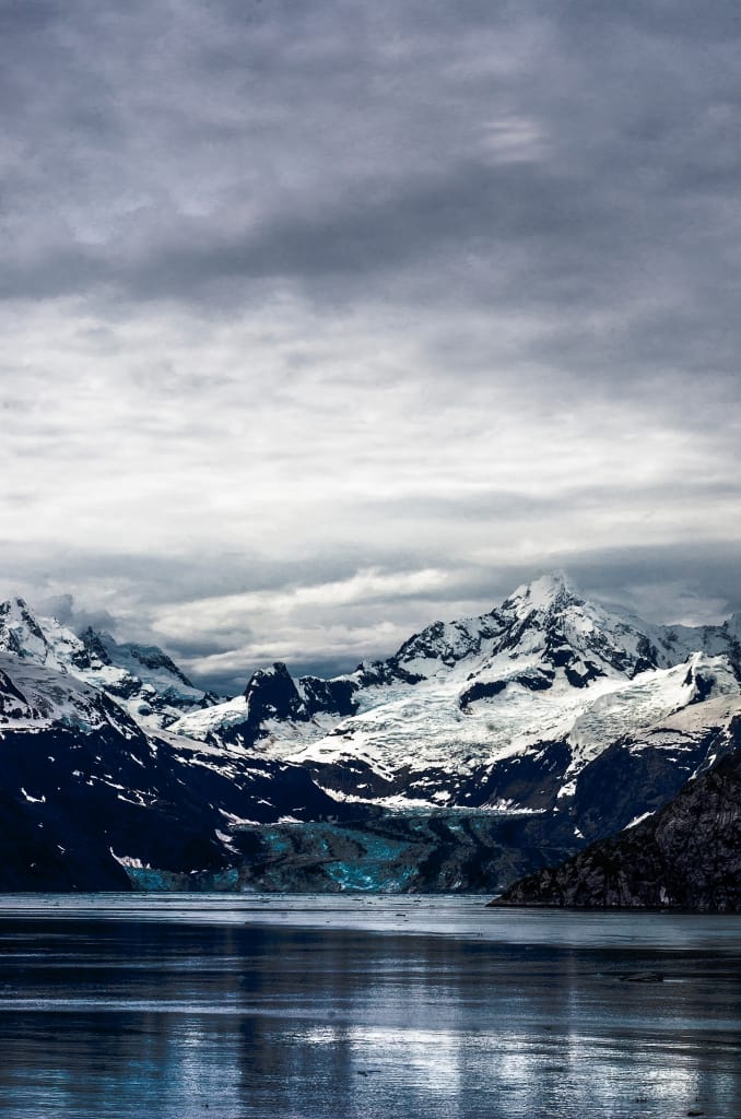 water and snow-covered mountains under a cloudy grey sky as proposal setting