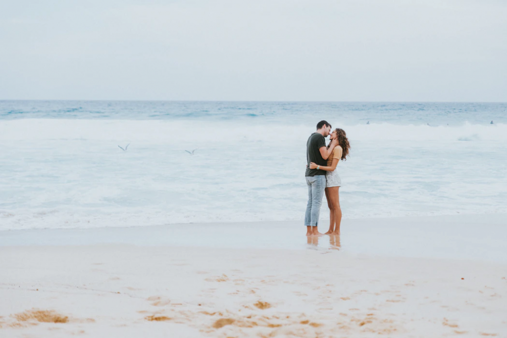 Couple kissing by the ocean